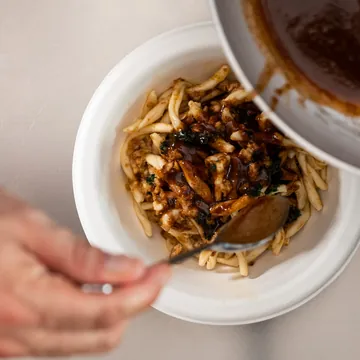 La salsa versata a cucchiaio sul piatto finito