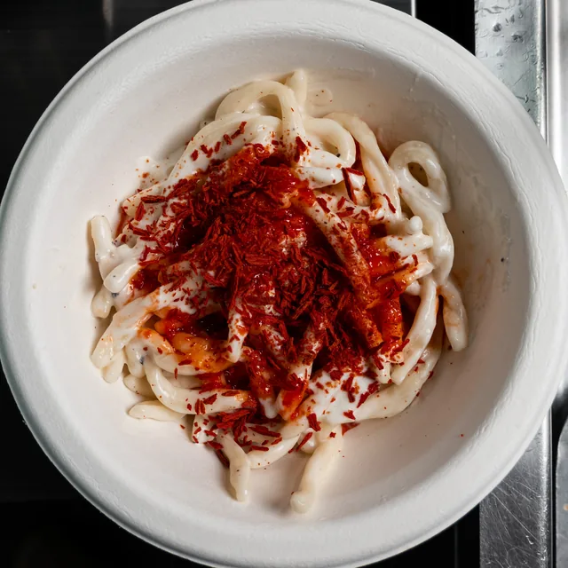 Strozzapreti con crema di squacquerone, caramello di peperone rosso e fiocchi di pomodoro, visti dall'alto